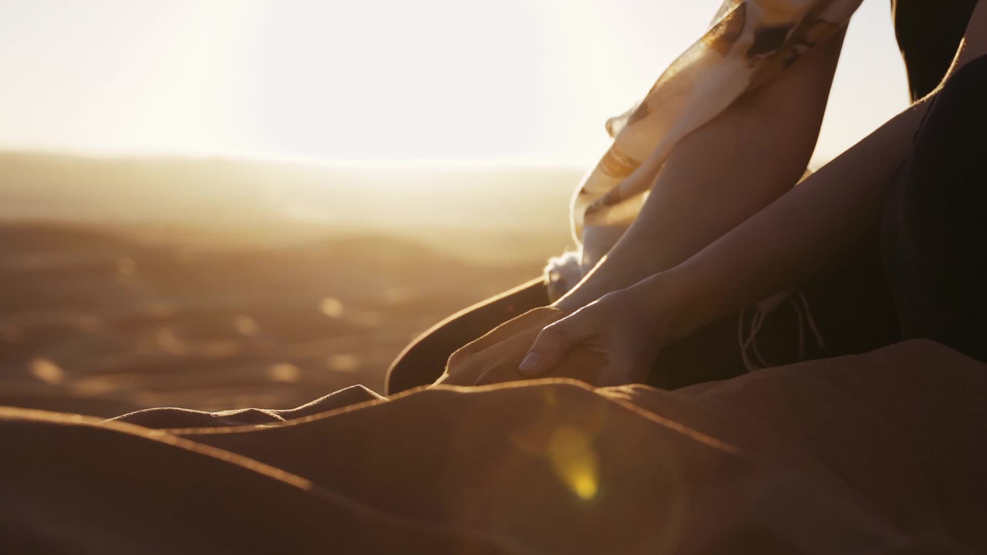 日落下的女孩子在沙滩玩沙子