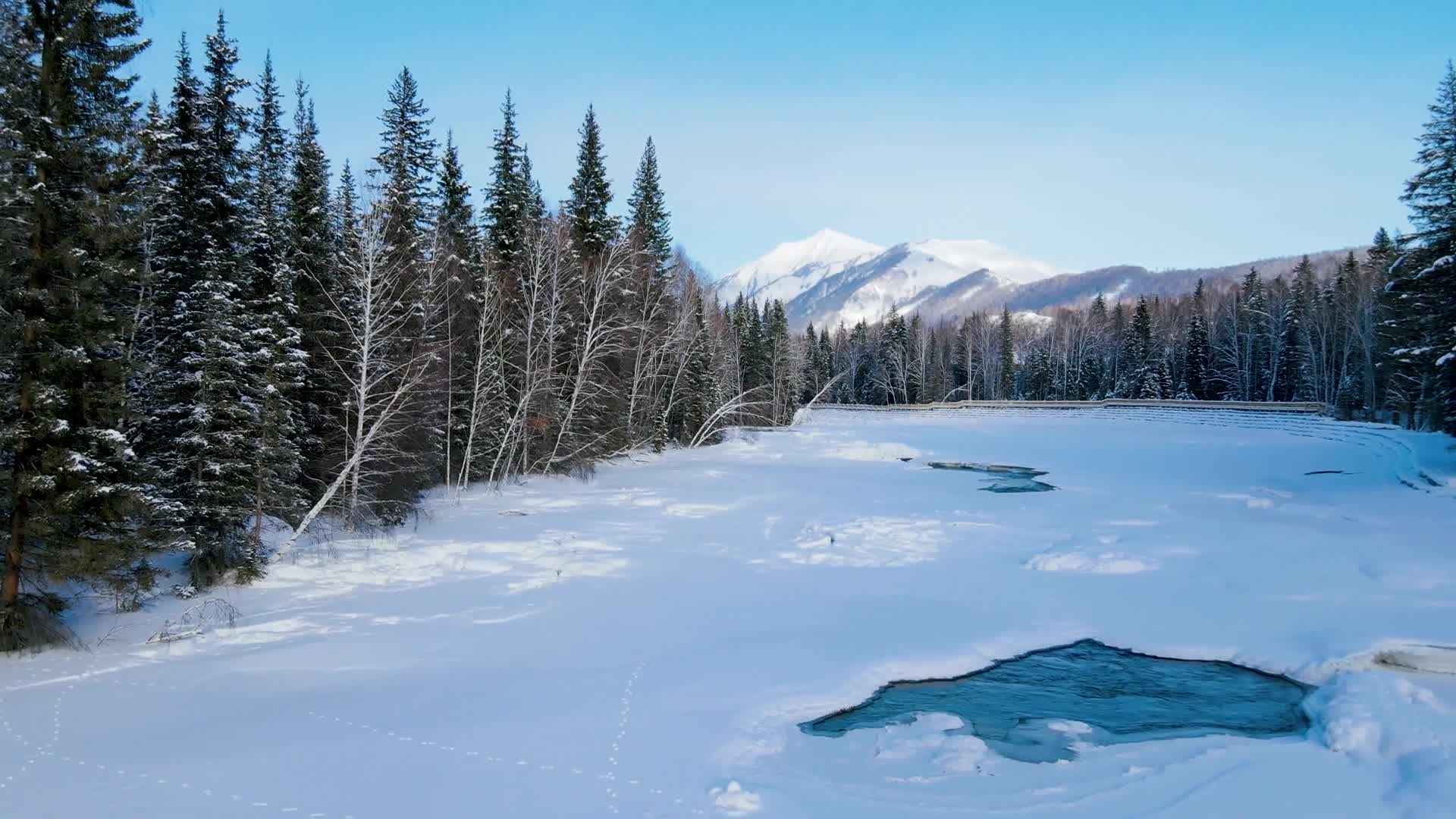 航拍冬季大雪后的森林湖泊视频素材