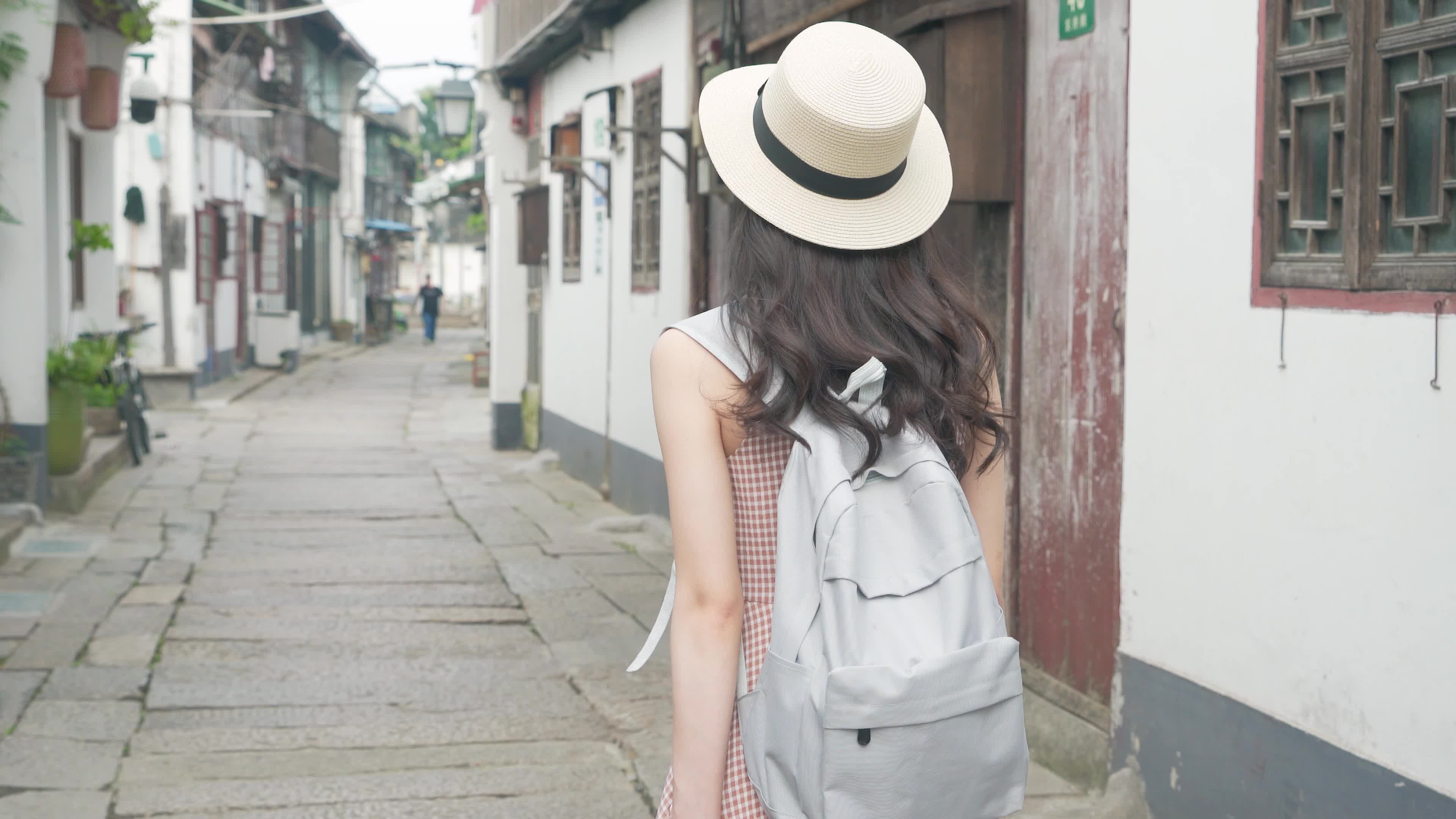 女孩旅游一个人在古镇的街道上行走