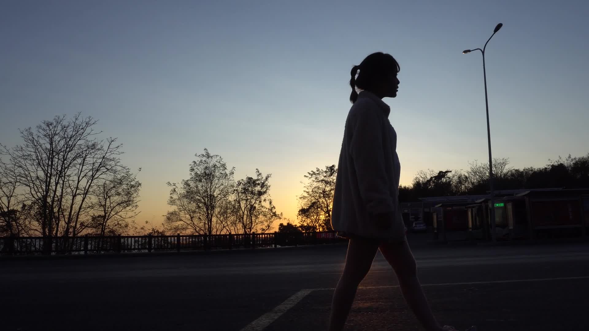 日落夕阳下女孩孤单伤感的行走在路上