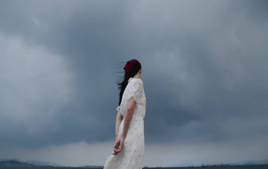 乌云下的女孩迎风吹舞