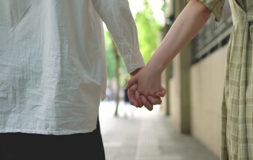 复古的小情侣手牵手在路边散步