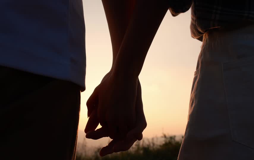 夕阳下情侣手牵手散步