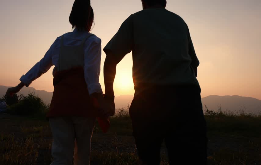 情侣牵手在夕阳下奔跑跳跃的视频