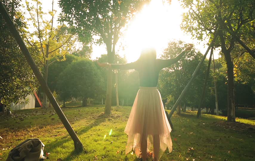 森林你女孩迎着阳光抛洒树叶