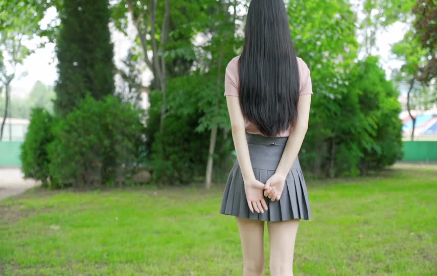 清纯的女孩子草地上行走的背影