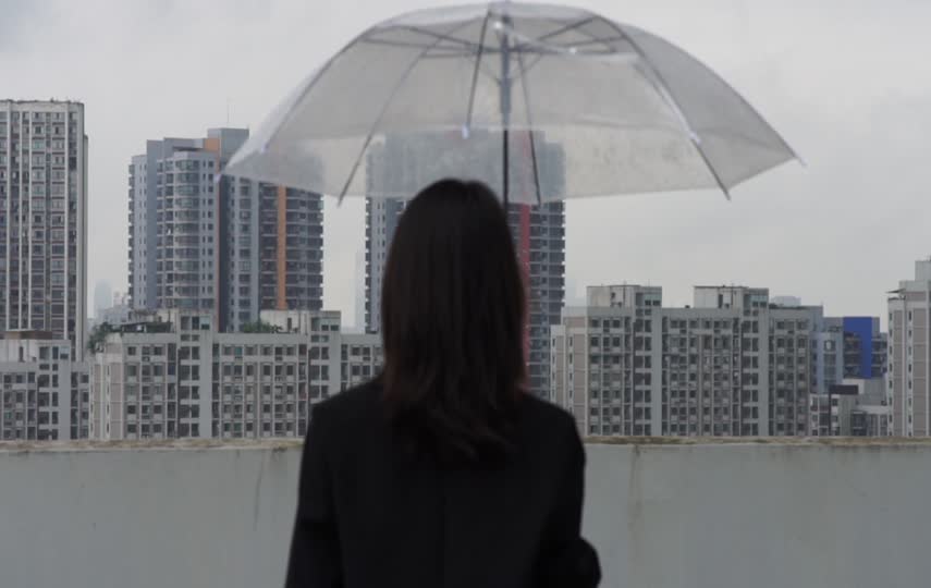 打伞的女孩在楼顶思考问题短视频素材