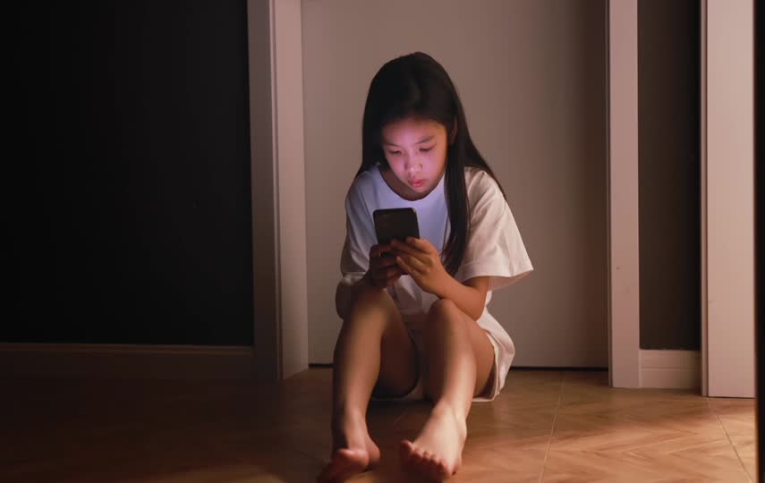 小女孩独自一个人玩手机短视频素材