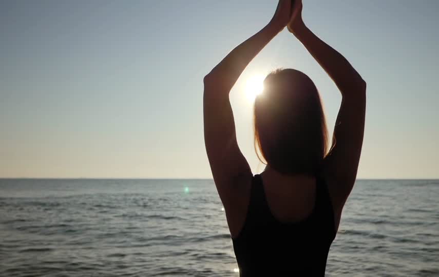 夕阳下在海边做瑜伽的美女视频素材